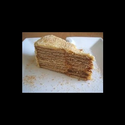 Fatia de bolo multicamadas castanha clara em prato branco