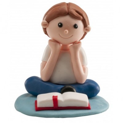 Figura decorativa de criança sentada lendo um livro