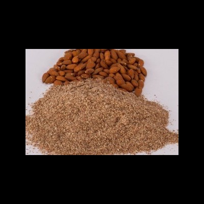 Amêndoas inteiras castanhas e amêndoas moídas em superfície branca