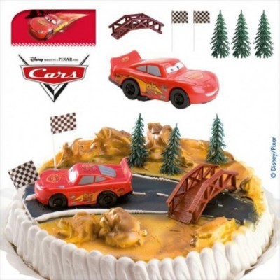 Bolo decorado com carros de brinquedo, árvores, bandeiras e ponte com temática do filme Cars