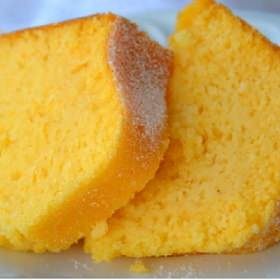 Dois pedaços de bolo amarelo com açúcar num prato branco