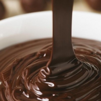 Chocolate líquido castanho-escuro e brilhante numa tigela branca