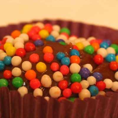 Doce com confeitos coloridos em forminha de papel roxa