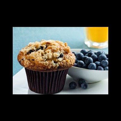 Muffin com mirtilos, tigela com mirtilos e copo de suco laranja