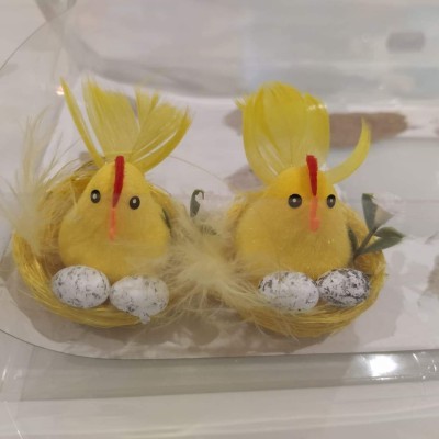 Duas decorações de pintainhos amarelos com ninhos e ovos em embalagem transparente