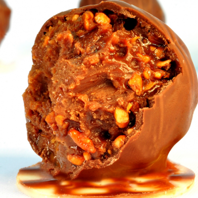 Bombom de chocolate ao leite com recheio cremoso e pedaços de nozes