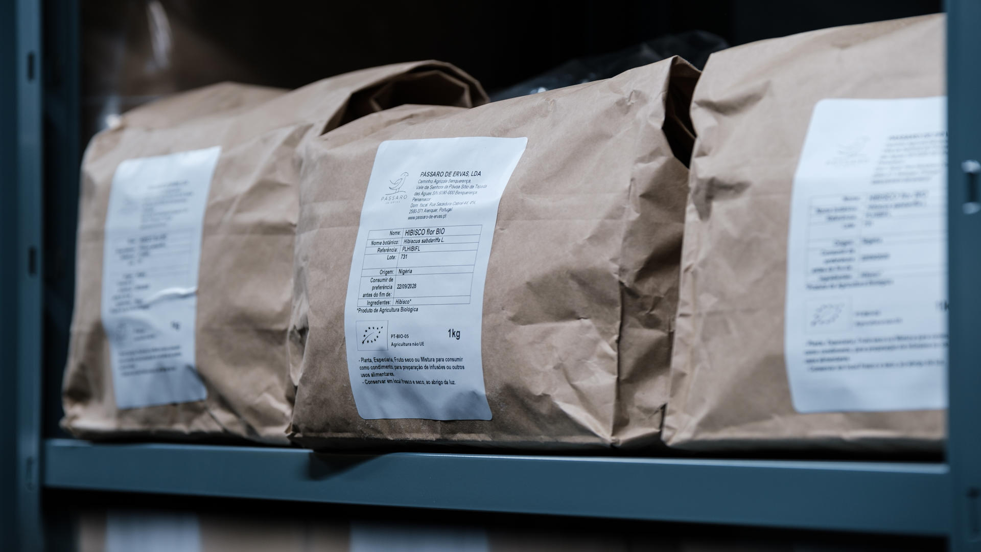 Pacotes de papel castanho com etiquetas brancas em prateleira azul