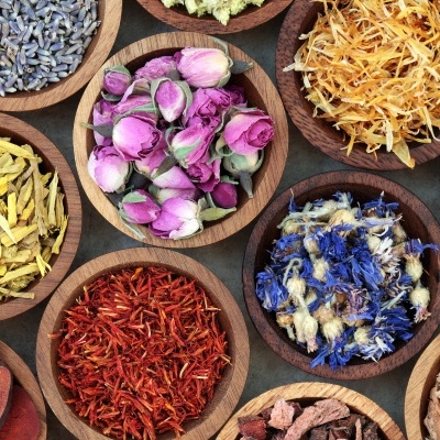 Tigelas de madeira com diferentes flores secas coloridas