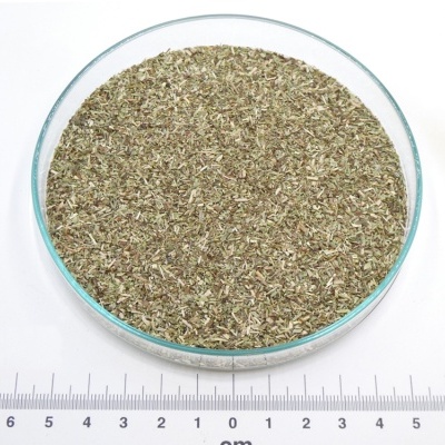 ervas secas picadas em placa de vidro sobre superfície branca com régua