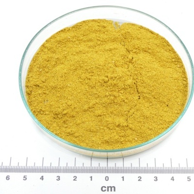 Pó amarelo em recipiente de vidro com régua de centímetros ao lado