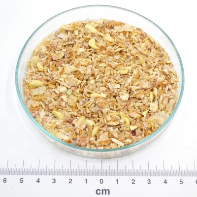 Mistura de ervas secas num prato de vidro com régua em centímetros e logo PÁSSARO DE ERVAS