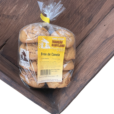 Pacote plástico com 8 pastelinhos Broa de Canela numa superfície de madeira escura