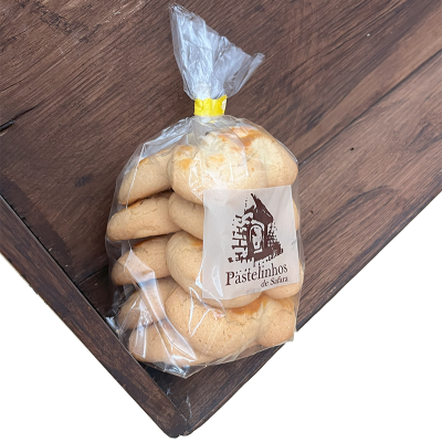 Pacote transparente com pastéis e etiqueta de moinho em superfície de madeira