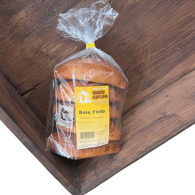 Pão embalado em plástico transparente com etiqueta amarela sobre superfície de madeira