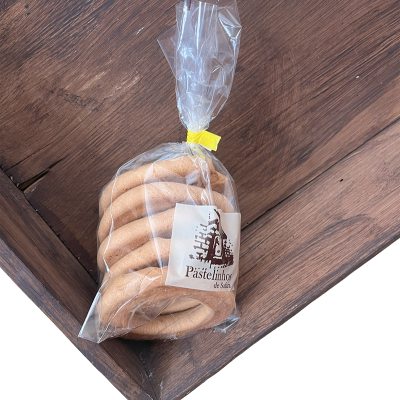 Pacote de pastelinhos de vidro em embalagem transparente com etiqueta e fecho amarelo sobre madeira.