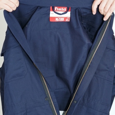 Casaco azul escuro com fecho de correr aberto e etiqueta FIELD BLAZE FLAME RESISTANT