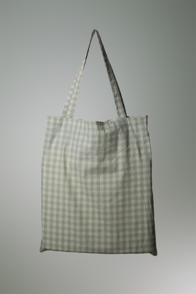 Saco tote bag xadrez verde claro e branco em fundo cinzento