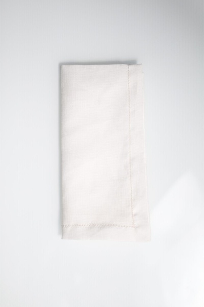 Guardanapo branco dobrado sobre superfície branca