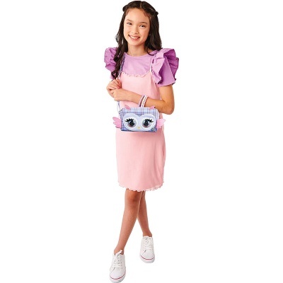 Menina com vestido rosa, camisola lilás, ténis brancos e carteira azul clara com olhos desenhados