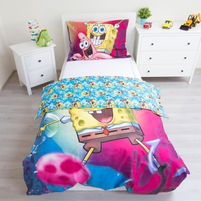 Roupa de cama Bob Esponja colorida em cama individual, quarto com móveis brancos e brinquedos.