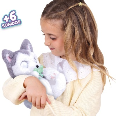 Menina a segurar um brinquedo de pelúcia cinzento e branco com biberão verde.