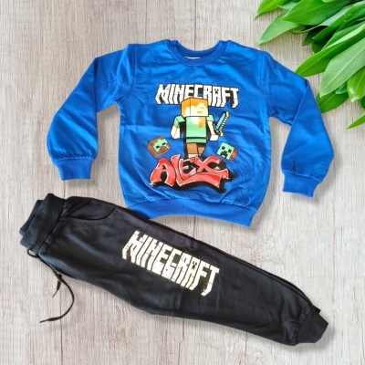 Conjunto infantil azul e preto com tema Minecraft, estampas coloridas e logótipo branco no chão de madeira.