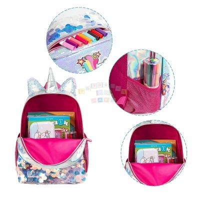 Mochila infantil cor-de-rosa com paillettes brilhantes e tema de unicórnio, mostrando compartimentos interiores com livros e material escolar