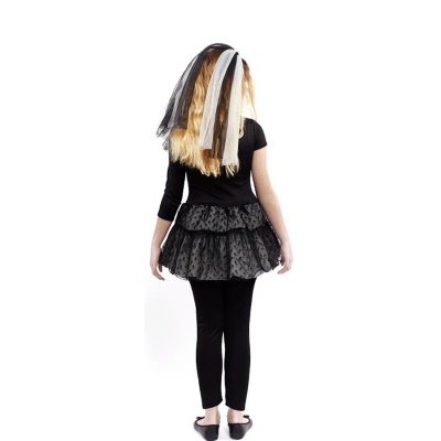 Criança de costas com fato preto, saia preta e leggings, cabelo loiro com fitas preta e branca