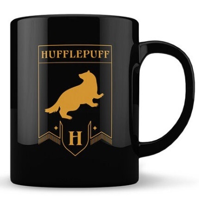 Caneca preta com emblema dourado da casa Hufflepuff.