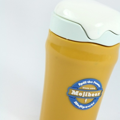 Copo térmico amarelo com tampa branca e etiqueta azul com texto Mojibear