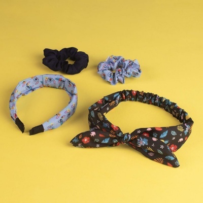 Conjunto de acessórios para cabelo com faixas e scrunchies coloridos sobre fundo amarelo