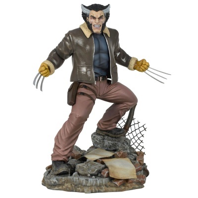 Figura colecionável do Wolverine com casaco castanho e garras em base de pedras e destroços.