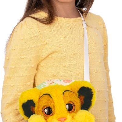 Criança com camisola amarela e peluche amarelo num saco com padrão de folhas