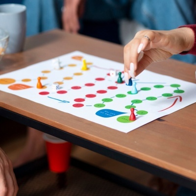 Jogo de tabuleiro com peças coloridas numa mesa de madeira