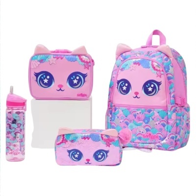 Conjunto escolar infantil rosa com padrão de escamas e rosto de gato com olhos grandes