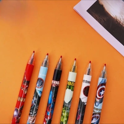 Seis canetas coloridas decorativas com tinta vermelha alinhadas em fundo laranja