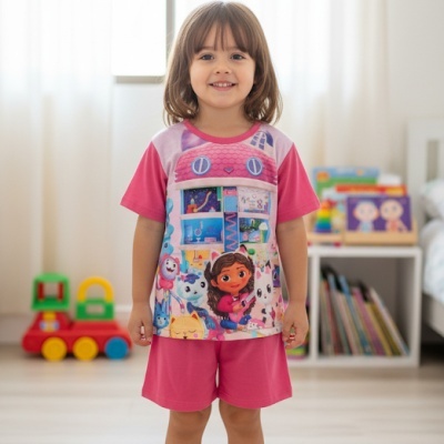 Menina com pijama rosa com estampa de personagens animados em ambiente interior