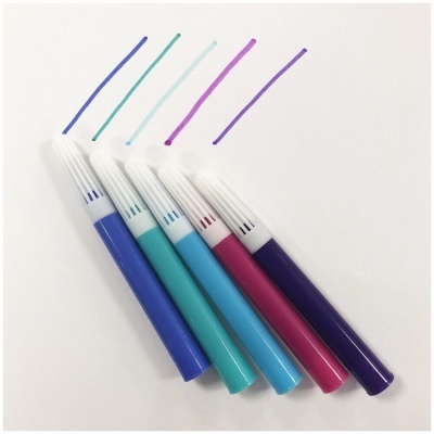 Cinco marcadores coloridos com tampas brancas desenhando linhas de diferentes cores sobre fundo branco.