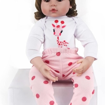 Boneca de bebé com roupas rosa e branca sentada