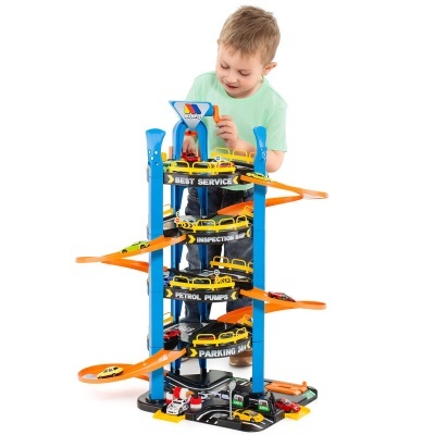 Parque de estacionamento de brinquedo com ramps laranja e vários carros, criança a brincar