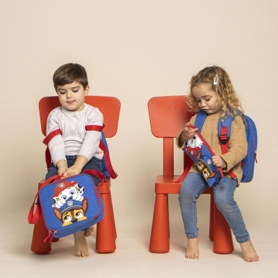 Crianças sentadas com mochila e lancheira azul com personagens animados