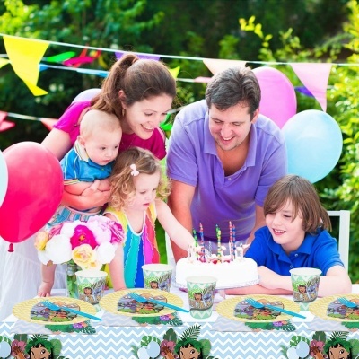 Mesa de festa infantil decorada com pratos, copos, bolo, balões e bandeirolas coloridas em jardim