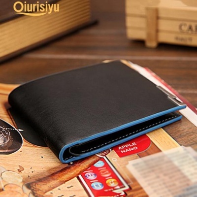 Carteira preta com borda azul sobre mesa de madeira com cartões e caixas ao fundo