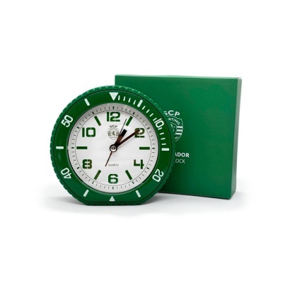 Relógio de secretária branco e verde ao lado de caixa verde com texto e símbolo branco