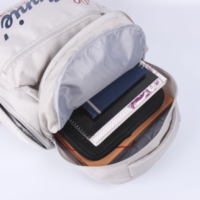 Mochila bege aberta com cadernos e pastas dentro