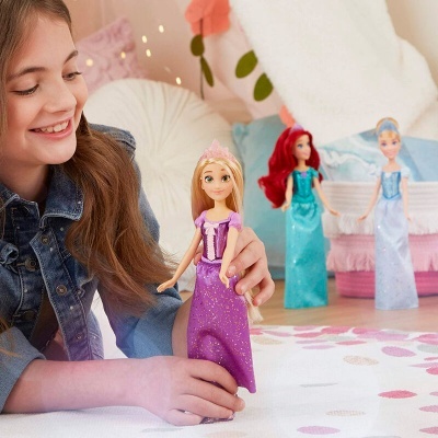 Menina a brincar com bonecas Princesas Disney robes roxas e azuis num quarto colorido