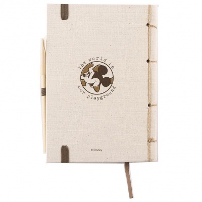 Caderno tecido cru com ilustração e texto à frente, caneta de madeira