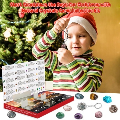 Criança com camisa às riscas e gorro de Natal segura pendente de cristal com kit de gemas naturais e árvore de Natal ao fundo