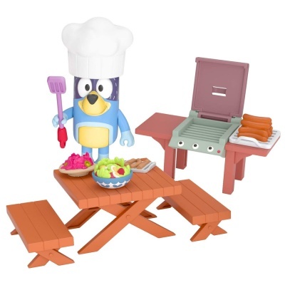 Brinquedo de personagem chef com mesa de piquenique, saladas e churrasqueira com salsichas