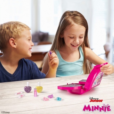 Crianças brincando com conjunto de cosméticos Disney Junior Minnie numa mesa
